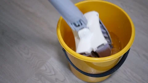 Automatic Mop Folding and Immersing into Yellow Water Bucket Preparing for Stock Footage 321527107