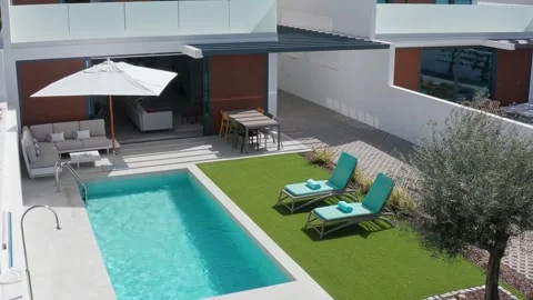 Automatic parasol deploying over pristine swimming pool, transforming luxurious Stock Footage 321009926