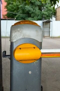 Automatic parking barrier gate with yellow arm for traffic control and security Stock Photos