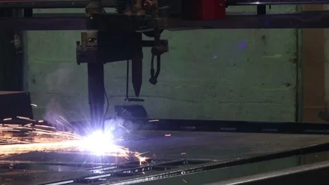 An automatic plasma cutter cuts a metal sheet at a metalwork factory sparks Video stock 166904204