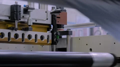 Automatic plastic bag making machine: perforating press unit: close up Stock Footage 276628283