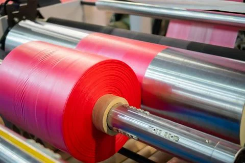 Automatic plastic bag making machine: moving roller with pink film at trade show Stock Photos