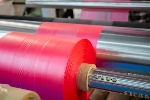Automatic plastic bag making machine: moving roller with pink film at trade show Stock Photos