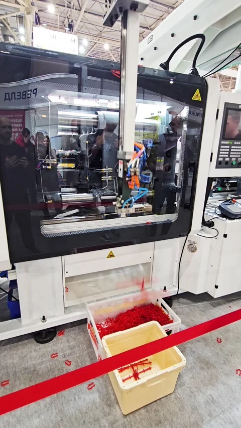 Automatic Plastic Injection Molding Machine with Robotic Arm operating Stock Footage 338166201