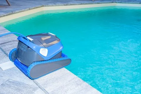 Automatic Pool Cleaner by the Poolside with Garden Background Foto stock