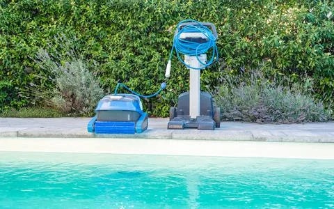 Automatic Pool Cleaner by the Poolside with Garden Background Foto stock