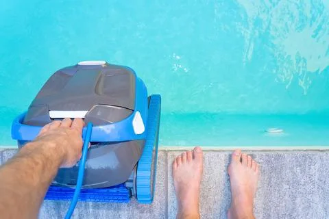 Automatic Pool Cleaner by the Poolside with Garden Background Foto stock