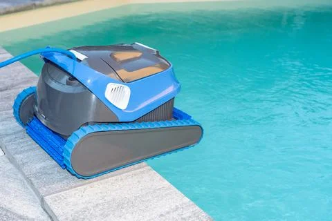 Automatic Pool Cleaner by the Poolside with Garden Background Foto stock