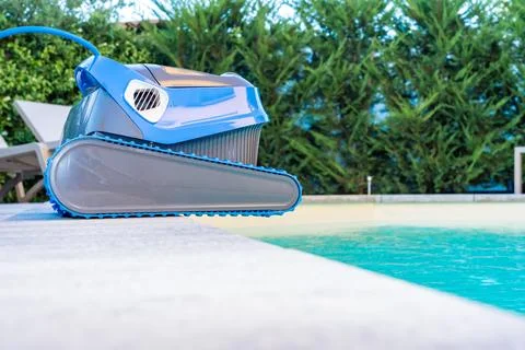 Automatic Pool Cleaner by the Poolside with Garden Background Foto stock