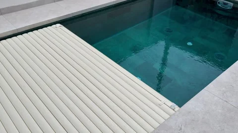 Automatic pool cover opening over a modern swimming pool Stock-Footage 344987265