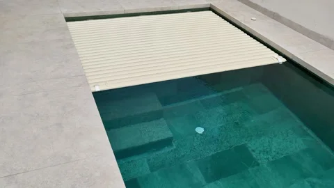 Automatic pool cover retracting over water Stock Footage 344987283