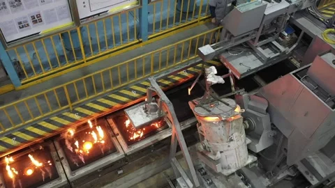 Automatic pouring equipment in a foundry is pouring molten iron into a sand mold Stock Footage 277430146