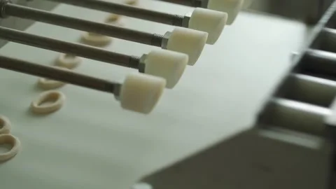 Automatic pretzel making machine. Baking buns on the production line in the Stock Footage 130667457