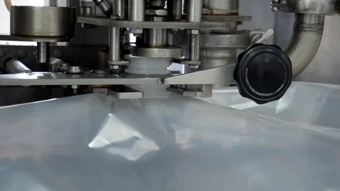 The automatic process of filling and bottling drinking yogurt and cream in the Stock Footage 129361808