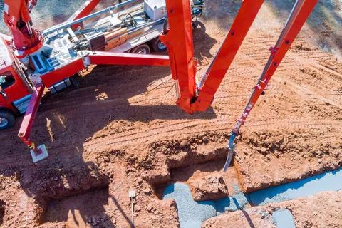 An automatic pump is used to direct cement concrete in construction process of a Stock Photos