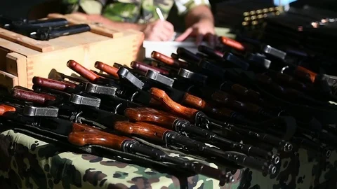 Automatic rifle with cartridges on a camouflage table Видео 83165735