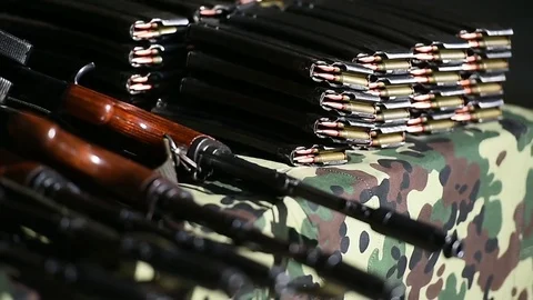 Automatic rifle with cartridges on a camouflage table Stockbeeldmateriaal 83165779