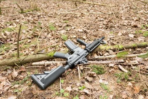 Automatic rifle m16 lying on the ground in the forest, lies in the forest, th Stock Photos
