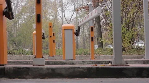 Automatic road barrier gate lifting gate opens and passes car Stock Footage