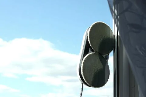 Automatic robot cleaner of windows and tiles during operation. Cleans the gla 스톡 사진