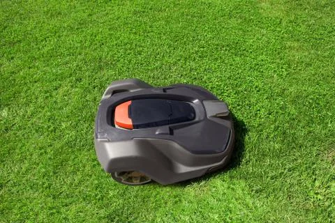 Automatic robot lawnmower mows grass on lawn, top view Foto stock