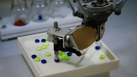 Automatic robot pharmaceutical industry. Robot automatically sorting balls Stock Photos