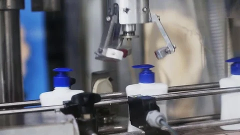 Automatic robot twists the caps on a conveyor belt Stock Footage 75227957