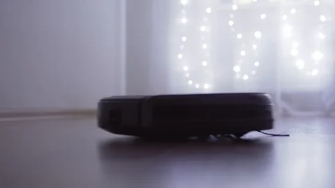 Automatic robot vacuum cleaner is cleaning the floor in the room Stock Footage 121313468