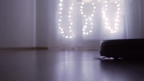 Automatic robot vacuum cleaner in the dark Stock Footage 121313400