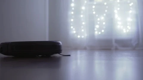 Automatic robot vacuum cleaner helps in cleaning the floor in the room Stock Footage 121314195