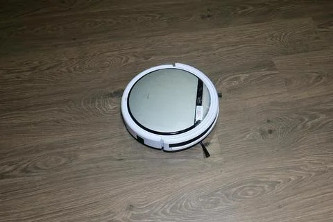 Automatic robot vacuum cleaner is white during operation. Cleans the floor. m Stock Photos