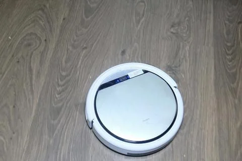 Automatic robot vacuum cleaner is white during operation. Cleans the floor. m Stock Photos