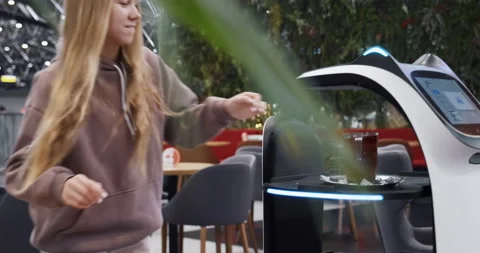 Automatic robot waiter brings order to young woman in the restaurant. Stock Footage 166522114