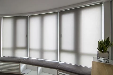 Automatic roller blinds beige color on big glass windows. Foto stock