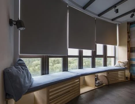 Automatic roller blinds beige color on big glass windows. Stock Photos