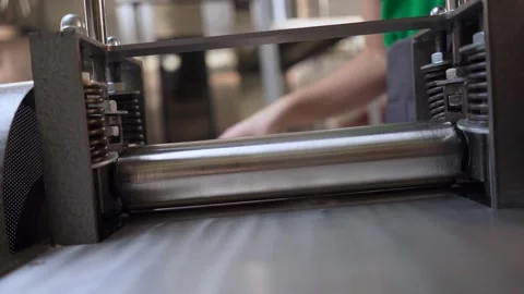 An automatic rolling of dough for dumplings. Machine that works the dough. Stock Footage 189279876