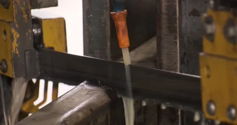 Automatic sawing machine cutting tool raw metal part on industrial band saw Stock Footage 168414508