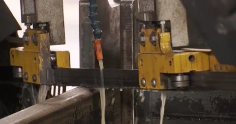 Automatic sawing machine cutting tool raw metal part on industrial band saw Stock Footage 188568909