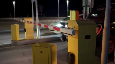 Automatic security system parking boom barrier car park system gate at night Stock Footage 125087532