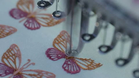 Automatic sewing machine embroiders the butterfly on a white cloth Stock Footage 60131722