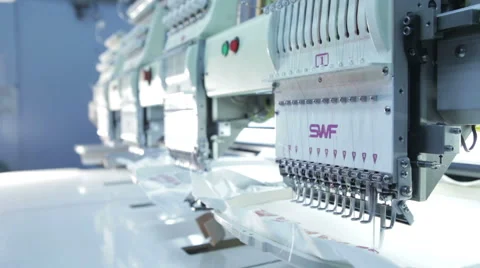 Automatic sewing machine embroiders on white cloth Stock Footage 60131731