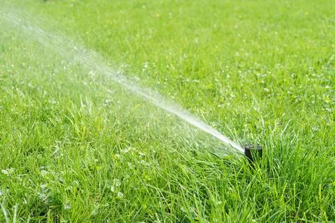 Automatic smart lawn sprinkler with adjustable head watering green lawn gra.. Stock Photos