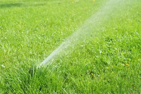 Automatic smart lawn sprinkler with adjustable head watering green lawn gra.. Stock Photos