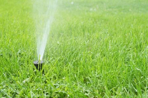Automatic smart lawn sprinkler with adjustable head watering green lawn gra.. Stock Photos