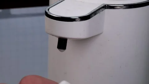 Automatic soap dispenser releasing foam onto a hand. Close-up shot of hygiene Stock Footage 314364211