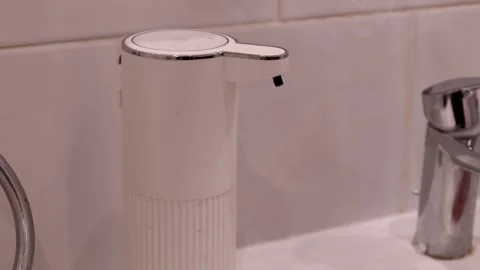 Automatic soap dispenser releasing liquid soap onto a hand. Handwashing and Stock Footage 314364357