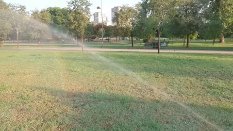 Automatic sprinkler system watering the lawn in the morning Stock Footage 283160681