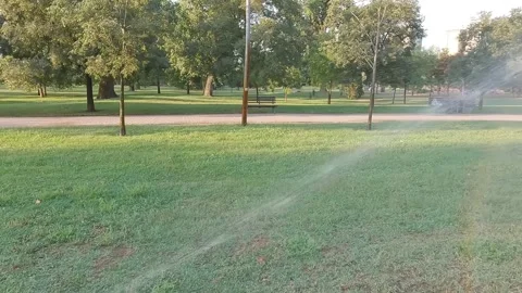 Automatic sprinkler system watering the lawn in the morning Stock Footage 283160695