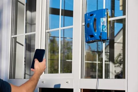 Automatic square-shaped window cleaner works on the window Stock Photos