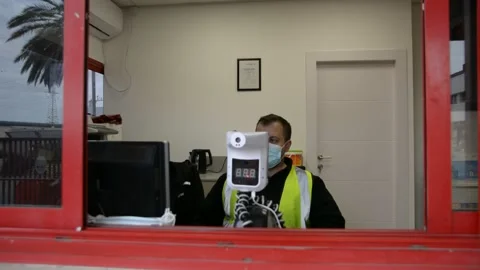 Automatic temperature measuring device and a security guard talking on the phone Stock Footage 147056269